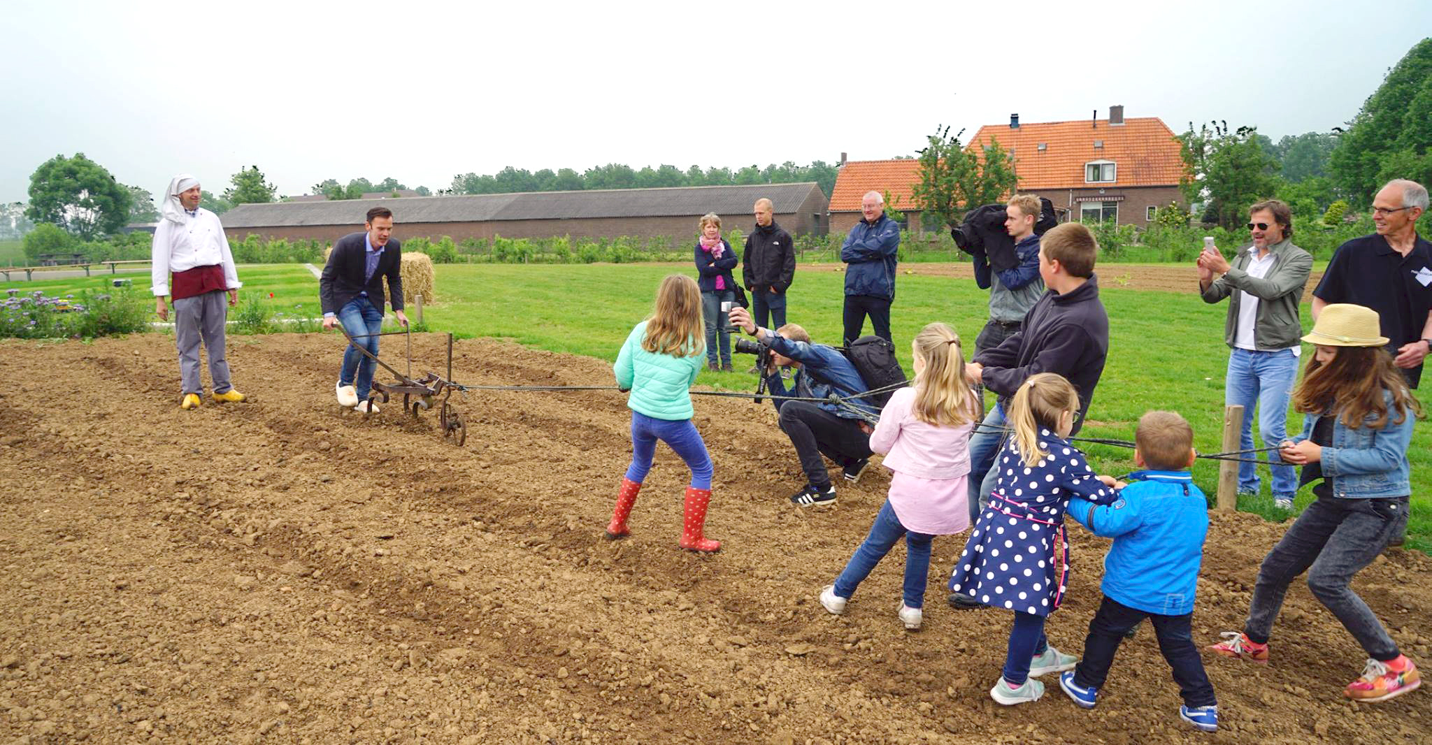 Openingshandeling - wethouder Wijnte Hol bewerkt het land